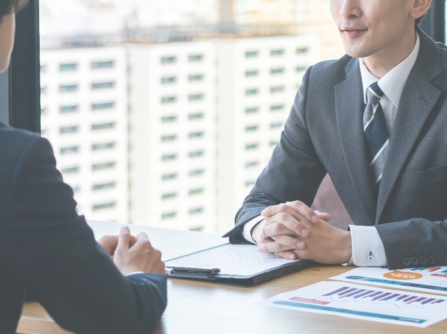 机をはさんで向かい合う人